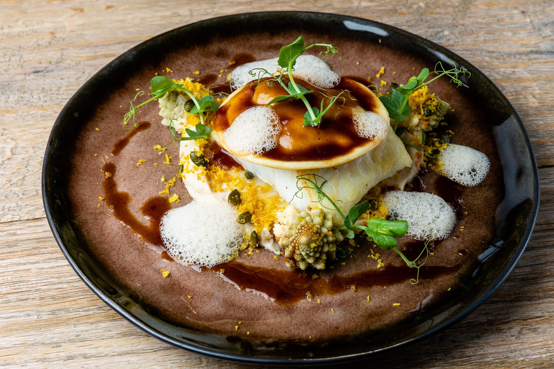 Restaurant Coast Fischgericht Filet vom Nordseesteinbutt mit geröstetem Blumenkohl „polnisch“ und Kalbsragout-Raviolo